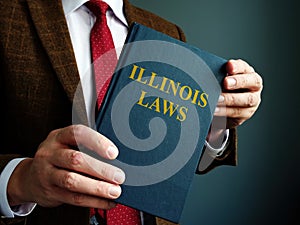 State Illinois law concept. A man in suit is holding a book.