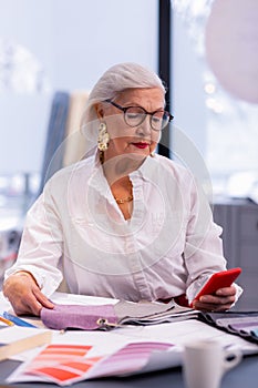 Stately business madam in years checking exchange on the phone