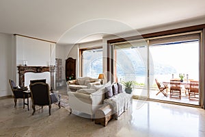 Stately living room with large windows overlooking the lake