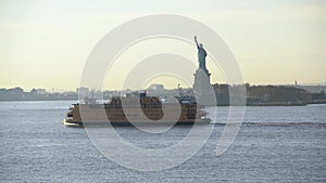 Staten Island Ferry passing Statue of Liberty. Sunset in New York City