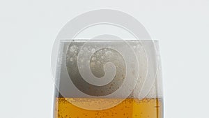 Static foamy beer goblet white background. Bubbled alcohol drink texture closeup