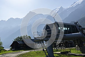 Station with chair lifts that runs near Les Houches. Silhouette of Alpine mountains photo