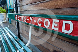 Station name on wooden bench at the railway station platform in Betws-y-Coed, a popular tourist town for outdoor pursuits