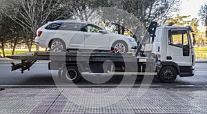 Station wagon car being towed by a tow truck