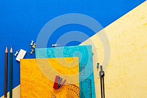 Stationary Background. Flat Lay Photo of Stationary and Geometry items on the Light yellow and blue background.