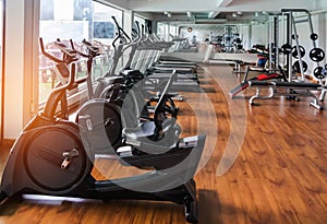 Stationary bikes and health exercise equipment in modern fitness center room