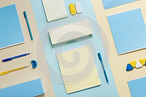 Stationary school supplies in yellow and blue tone. Office accessories on paper background.