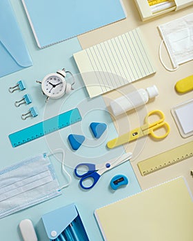 Stationary school supplies in yellow and blue tone. Office accessories and personal protective equipments