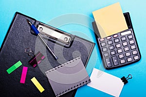 Stationery and calculator. Business card with binder near sticky notes