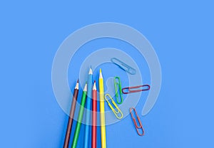 Stationery office supplies, Colored pencils with colorful clips on blue background