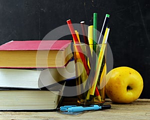 Stationery (pen, pencil, ruler, compass) and a book on black school board