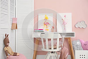 Stationery and pictures on white table in children`s room. Interior design