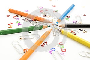 Stationery products, many colored pencils and clasps isolated in