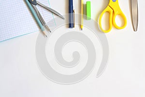 Stationery on a white background, notebook pens, pencils, compasses, eraser and scissors, flat lay, copy space, top view