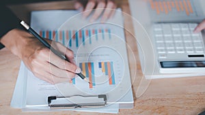 statistical analyst using calculator to calculate and read reports , graphs and charts, business statistics ,Analysis and