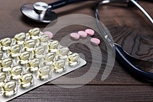 Statoscope and pills over wooden table