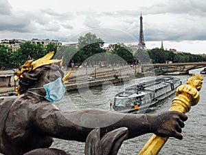 Statue at Alexander III bridge with a surgical mask in Paris