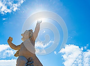 Statue of angel boy with sky in background