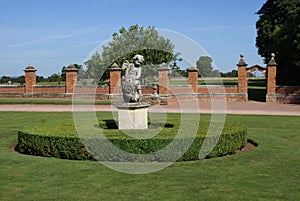 Statue of an angel on a lion and hedge