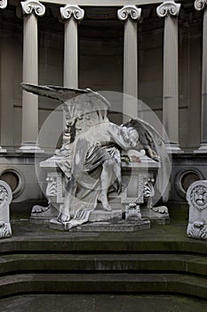 Statue of an angel lying on a tomb regretting the loss photo