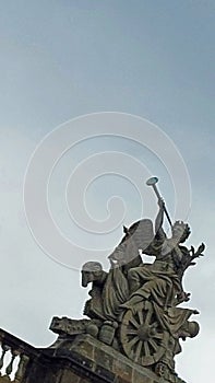 Statue with angel sounding trumpet on chariot
