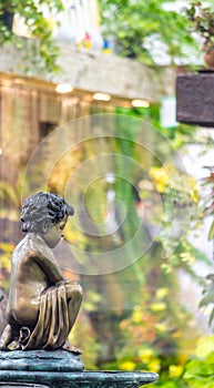 Statue of angel and waterfall in cozy garden.