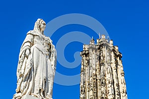 Statue of Archduchess Margaret of Austria and the tower of Saint Rumbold`s Cathedral in Mechelen, Belgium