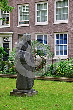 Statue of a Beguine in the beautiful courtyard of The Begijnhof at Amsterdam