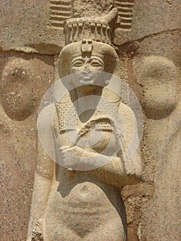 A Statue of Bintanath, stands in front of the legs of Ramesses