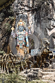 Statue of a blue hindu god Shiva with a horse driven chariot in Batu Caves Kuala Lumpur Malaysia