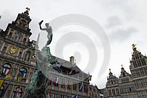 Statue of Brabo and the giant`s hand with the Antwerp City Hall in Antwerp