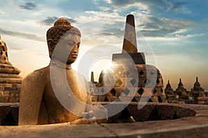 Statue of Buddha against the background of the sunrise in the temple of Borobudur. Java island. Indonesia.