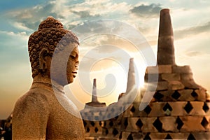 A statue of Buddha against the background of the sunrise in the temple of Borobudur. Java island. Indonesia.