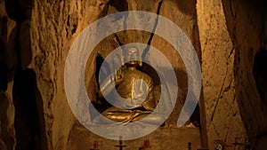 Statue of Buddha showing sacral murda in niche in cave
