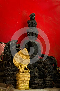 Statue of a buddhist asura, a demigod with many faces, on display in a temple in Phuket, Thailand