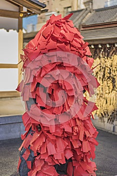 Statue of the Buddhist deity Akagami Nio covered with red papers deposited by the faithful to purify and heal the sick parts of photo
