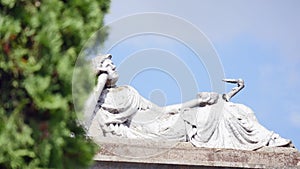 Statue in a cemetery with clouds