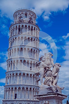 Statue of cherubim on the background of the leaning tower