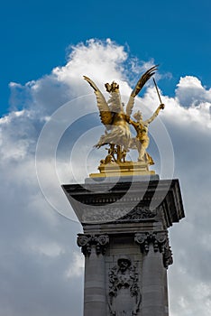 Statue on column at Alexander III bridge in Paris