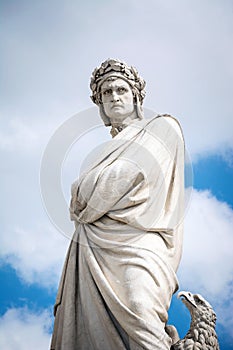 Statue of Dante Alighieri in Piazza di Santa Croce with cloudy sky background. Florence, Italy.