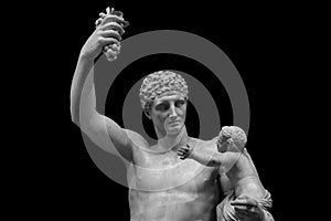 Statue of Dionysus or Bacchus with bunch of grapes isolated on black