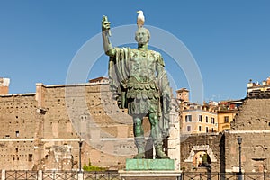 Statue of the Emperor Trajan with seagull on his head with Trajan`s Forum and market on background, Rome