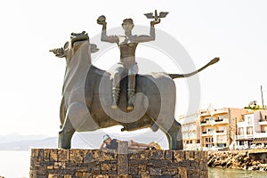 The statue of Europe is sitting on a bull. Sculpture of Europe, mother of King Minos, riding a bull in Agios Nikolaos