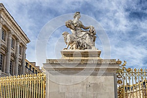 Statue in exterior fence of facade of Versailles Palace