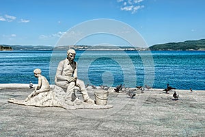 A statue with fisherman and son resting on the shore theme