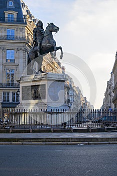 Statue of the French King Louis XIV (14th) in the center of Victories Place in Paris under a pure cold blue sky