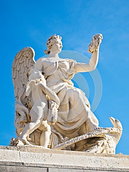 Statue with garland at facade of Versailles