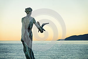 Statue of a Girl Holding a Seagull at Sunset in Opatija, Croatia