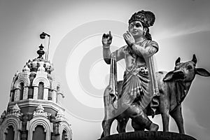 Statue of god Krishna with an invisible flute.  Temple tower decoration