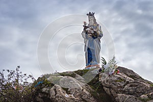 Statue of God Mother with Jesus baby in Pyrenees mountains, France. Sculpture of Our Lady with Jesus Christ on mountain top.